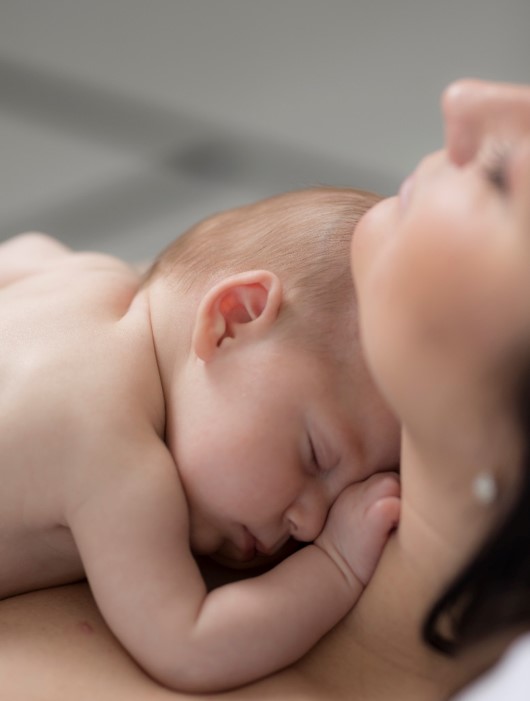 Nyfödd bebis ligger hud mot hud med sin mor