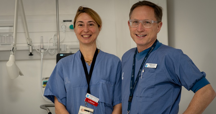 Francesca Bresso och Mattias Soop står i blå läkarkläder i ett patientrum