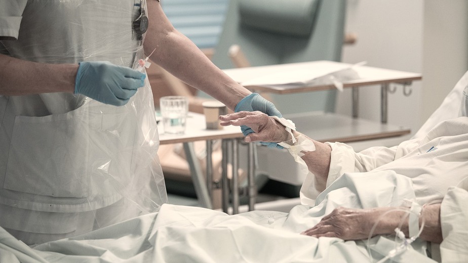 Vårdpersonal ger patient en injektion i armen