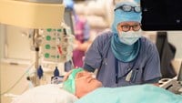 Narkossjuksköterskan Carin Jansson Söderlund lägger en lugnande hand på patienten Björn.