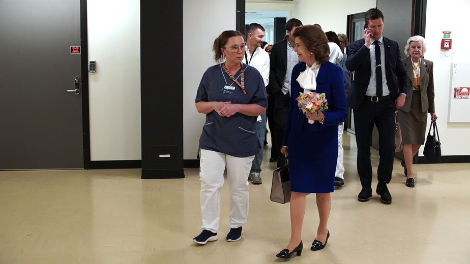 Drottning Silvia promenerar i korridoren tillsammans med omvårdnadschefen Pernilla Hjelm.