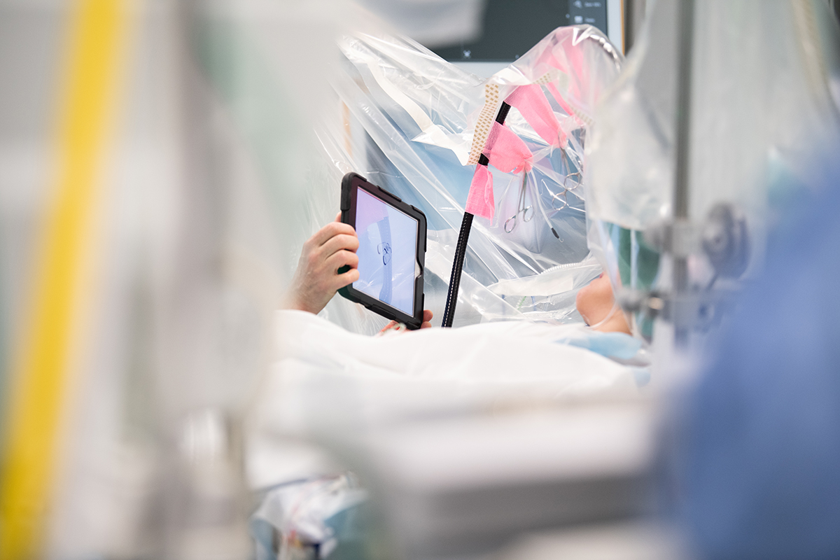 Förberett operationsbord med fokus på en iPad som visas upp för patienten