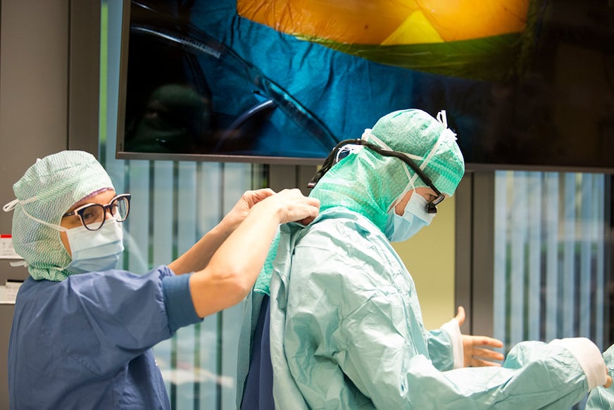 Två personer klädda i operationskläder