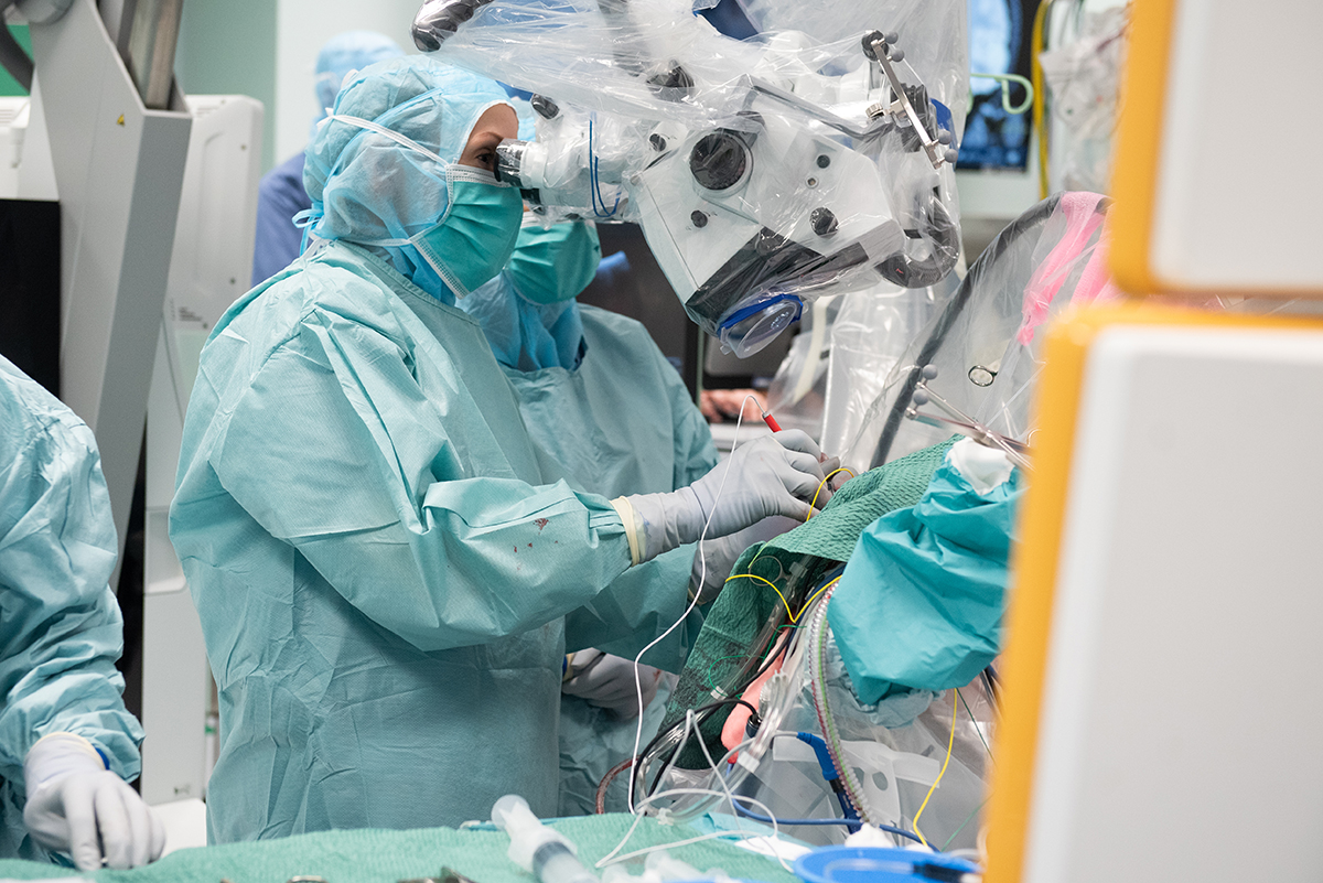 Neurokirurg tittar igenom förstoringsinstrument under pågående hjärnoperation