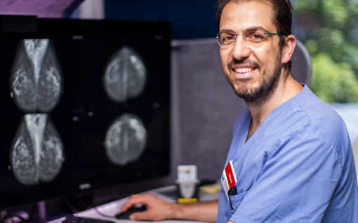 En man sitter framför en datorskärm och granskar en röntgad hjärna