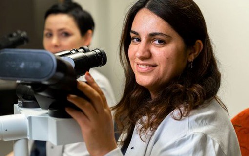 Bild på två tjejer på cytologilab som tittar i mikroskop
