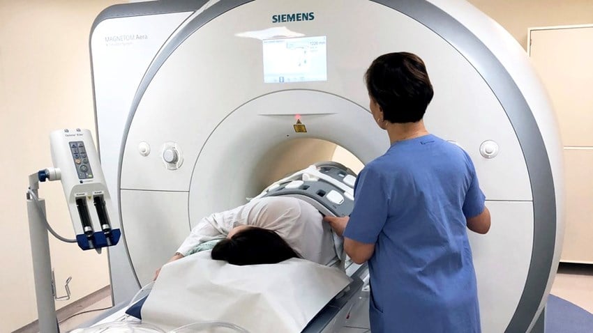 Patient ligger i magnetkamera med personal brevid