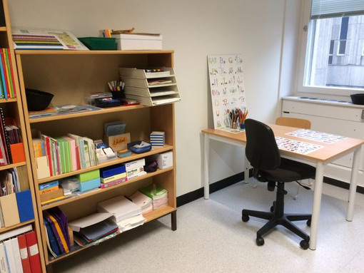 Bilden föreställer ett rum med skrivbord och pedagogiskt material.