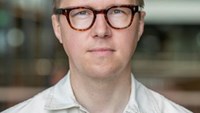 Petter har blont kort hår och bruna runda glasögon.