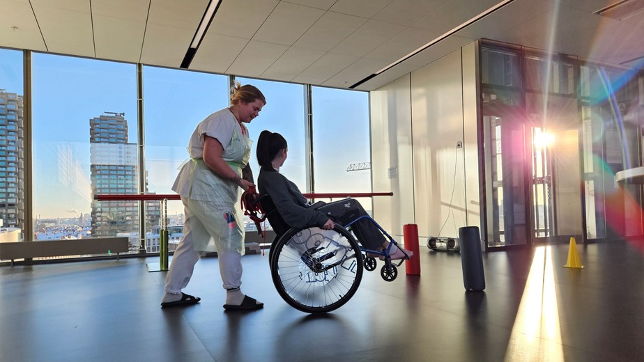 vårdpersonal kör patient i rullstol