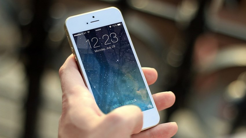 En hand håller i mobiltelefon