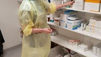 skyddskläder på person bland medicin