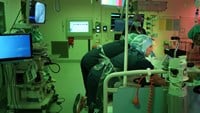 Cechael och de övriga i vårdteamet hjälps åt att flytta en patient till en ny säng.