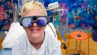 Blond pojke med svarta VR-glasögon på sig