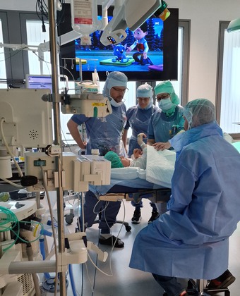 ett barn och operationsklädd personal i operationssal