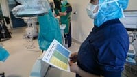 En sjuksköterska håller en checklista för operation i sin hand.