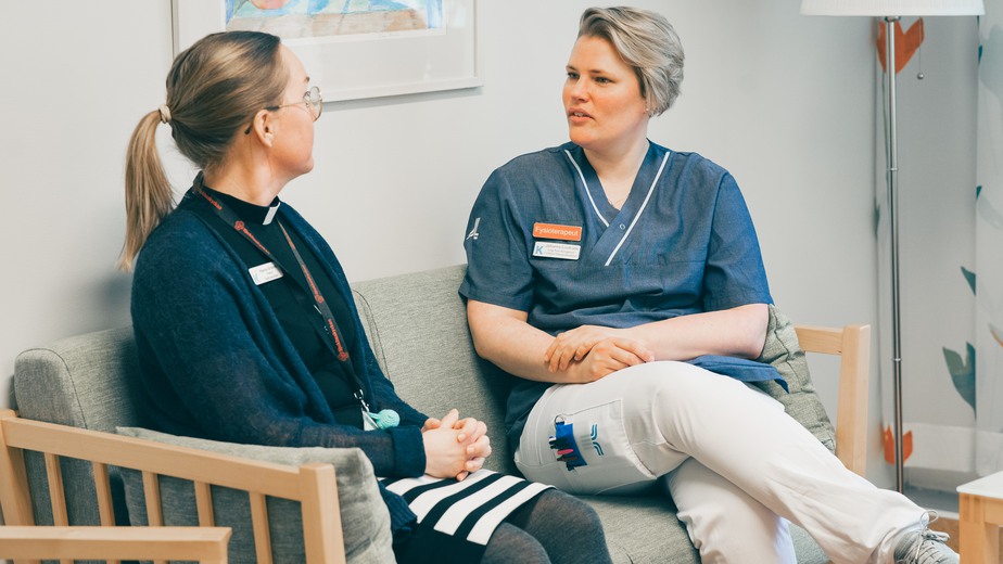 Hanna och Johanna sitter i en soffa och samtalar.