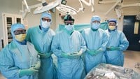 Operationsteamet står uppradade framför patienten.