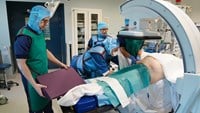 Operationsteamet placerar kuddar under patienten.
