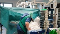 En manlig sjuksköterska småpratar med patienten.