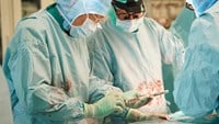 En ortoped mäter ett instrumentet som ska användas för att preparera bäckenet.