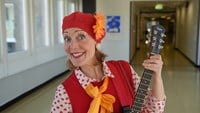 Truddiluttan i röd basker med en stor orange blomma på.
