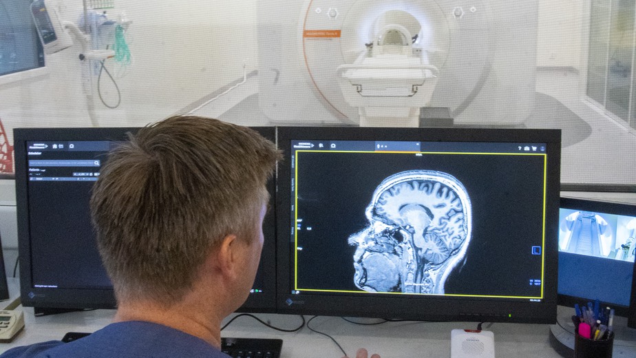 Sektionschef Tobias Granberg tittar på röntgenbild av ett huvud.