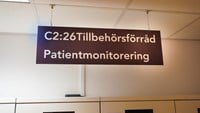 brunt skylt med texten "Tillbehörsförråd patientmonitorering"