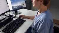 kvinna framför två datorskärmar