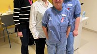 Fem glada medarbetare på en gruppbild