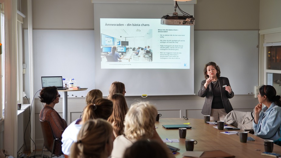 En kvinna som håller en presentation för en grupp människor.