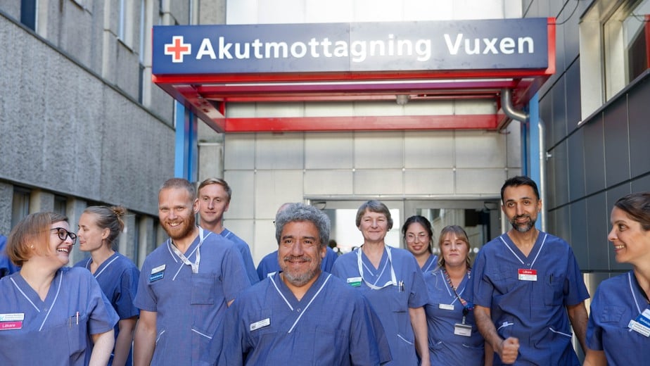 glad vårdpersonal går ut från akutens entré