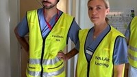 En man och en kvinna i gula västar står bredvid varandra.