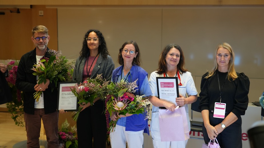 Pristagarna med blommor och diplom på scenen i Sune Bergströms aula på Karolinska Universitetssjukhuset