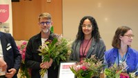 Per Nydert och Hanna Gottlieb på scenen med blommor, diplom och stora leenden.