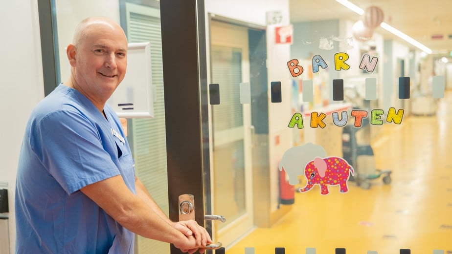glad man öppnar dörr med texten Välkommen till barnakuten