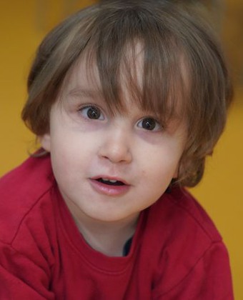 Treårige Malik iklädd röd tröja leker i väntrummet på Barnneurologen.