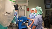 En grupp operationsmedarbetare som står runt en robot.