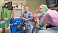 En grupp operationsmedarbetare lyssnar på en kvinnlig sjuksköterska.