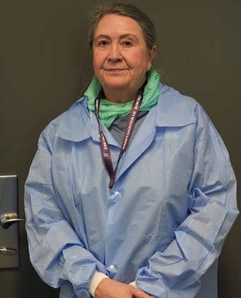Ingrid Abrahamsson Stackeryd, anestesisjuksköterska, bär blå sjukhuskläder och håller händerna över varandra framför bröstet