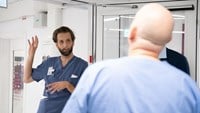 Vårdpersonal och sjukhusdirektören Christophe Pedroletti står och pratar vid en sjukhuskorridor. 