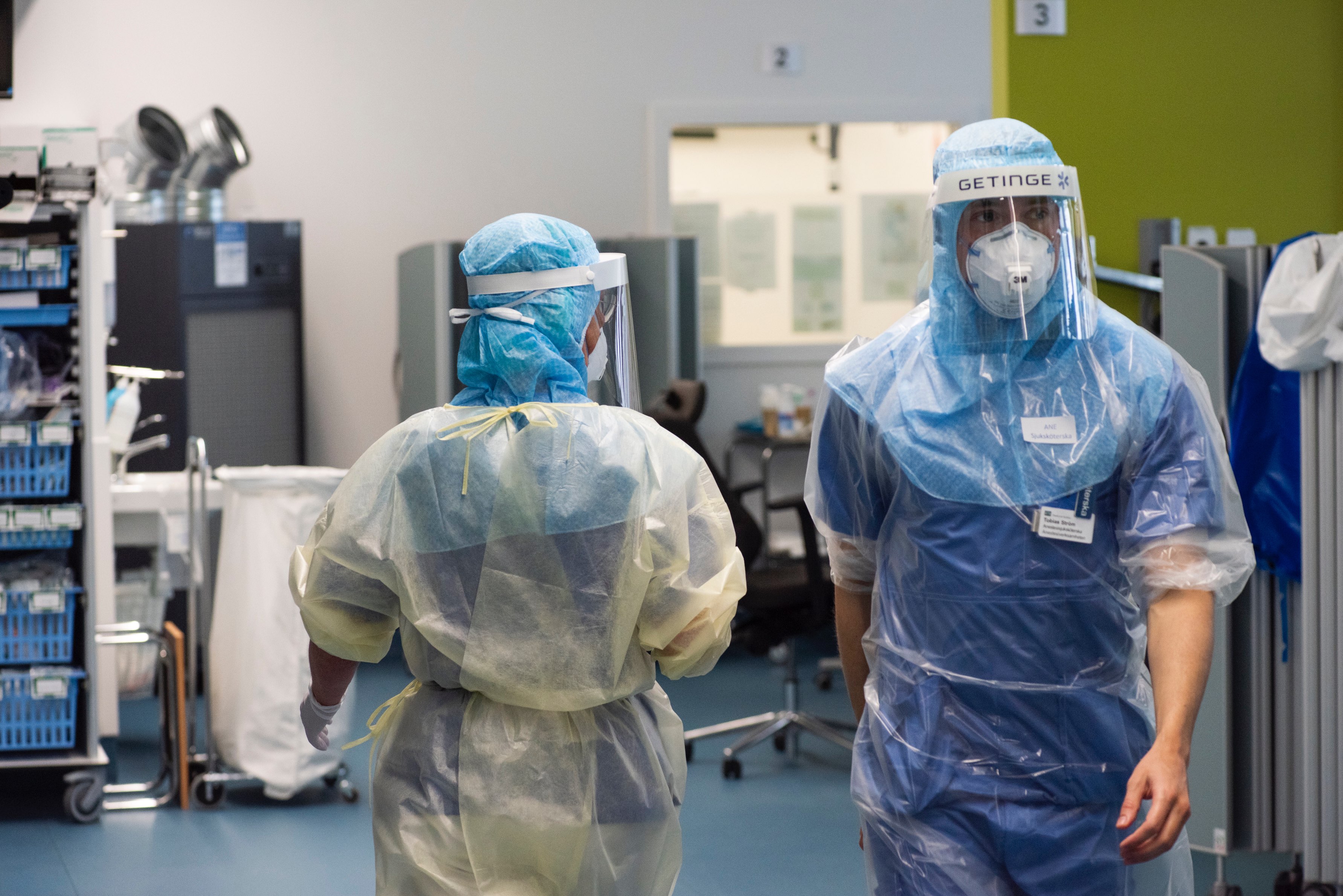 Ett team av intensivvårdsmedarbetare arbetar i skyddsutrustning med en patient.