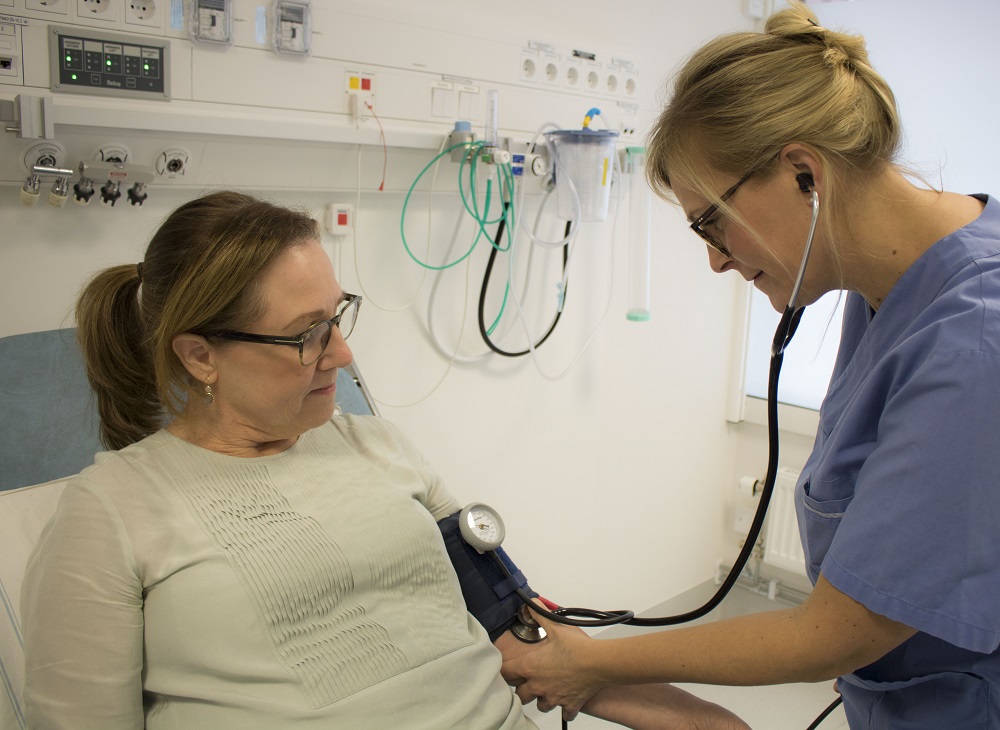 En vårdklädd och patient vid blodtrycksmätning