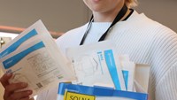person håller upp förpackning med andningsskydd