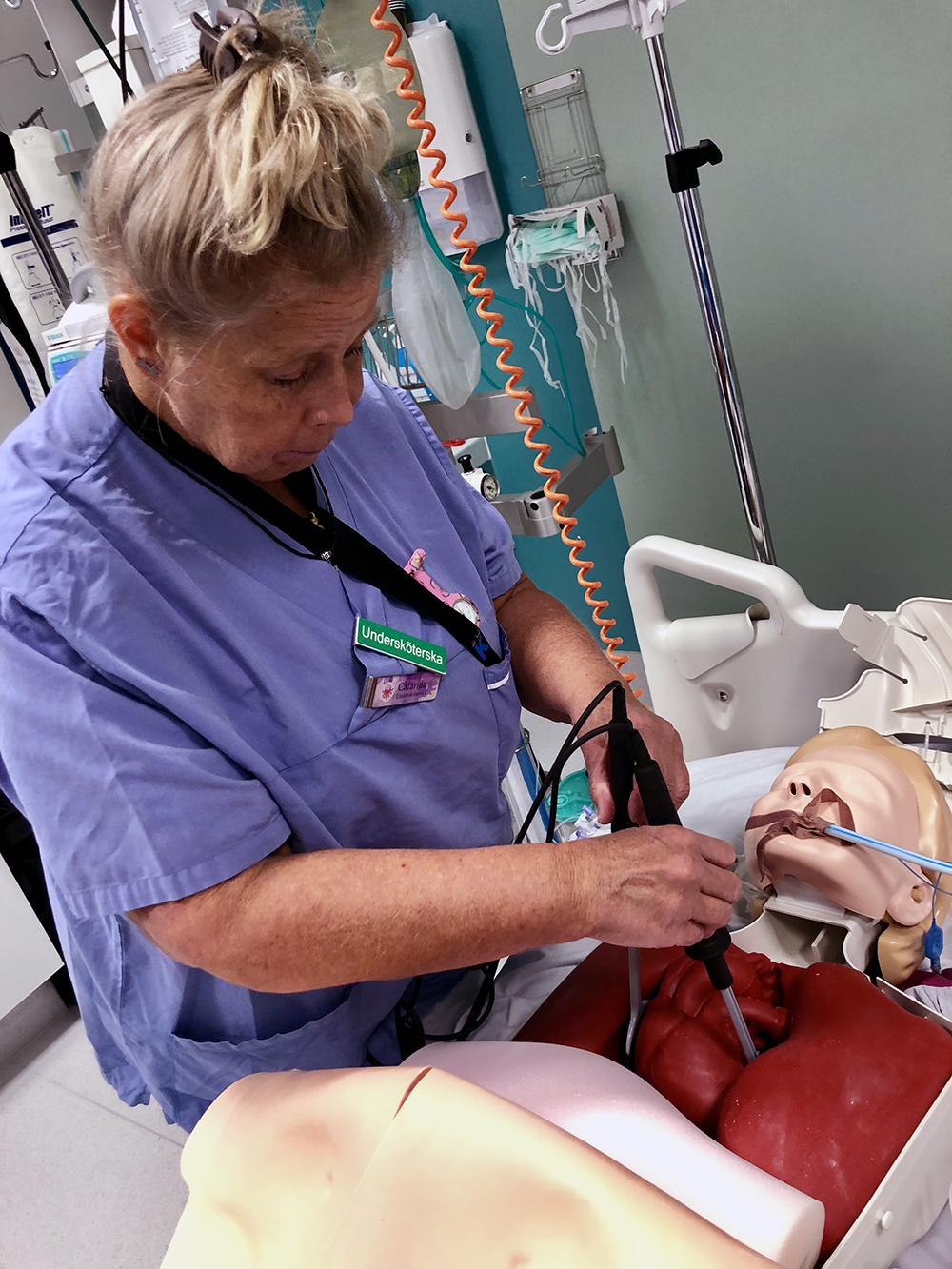 Undersköterska defibrillerar ett konstgjort hjärta med interna spatlar.