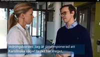 Två personer står och pratar med varandra.