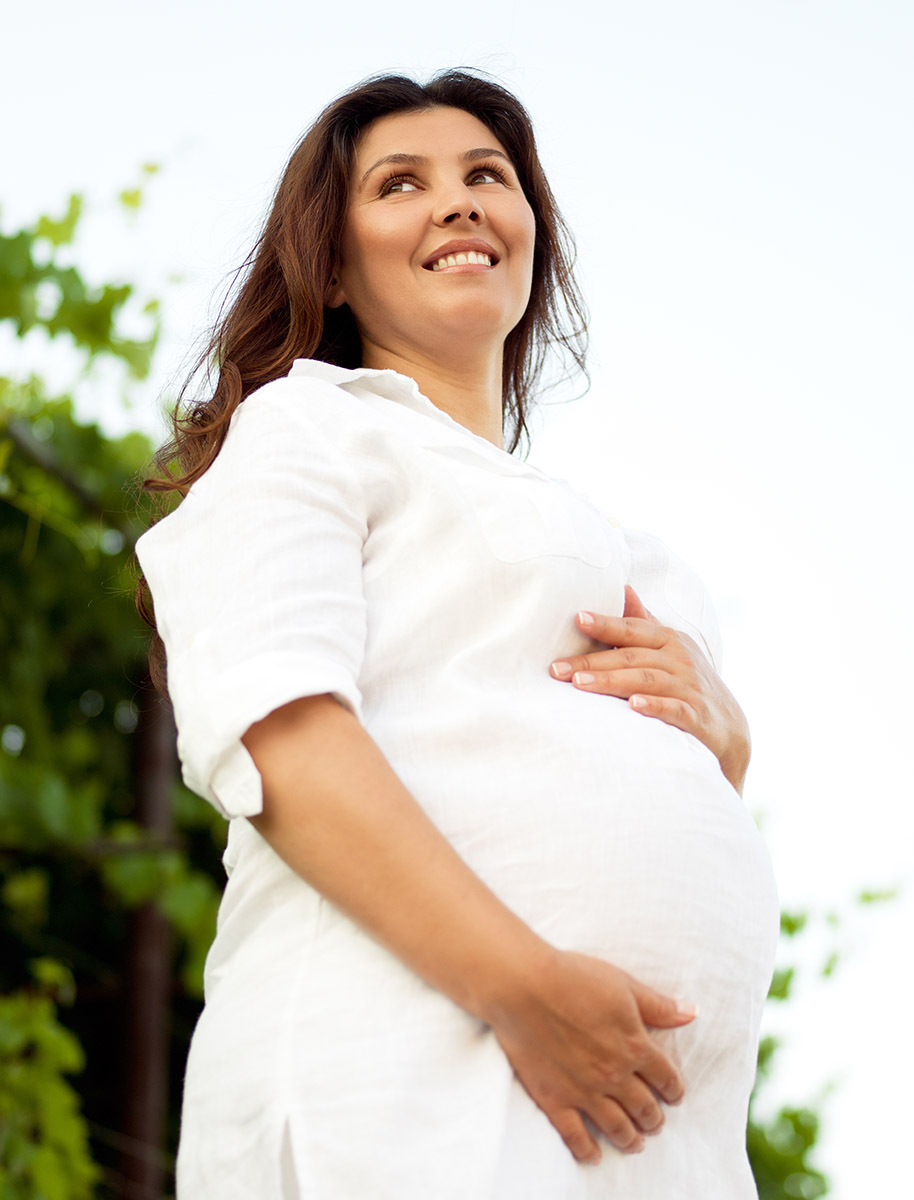Gravid kvinna håller sig om magen. Foto: Karolinska Universitetssjukhuset