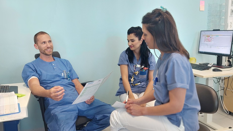 Tre sjuksköterskor samtalar med varandra vid en överlämning.
