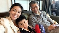 Mamma Lalitta, Ari och pappa Kavin sitter bredvid varandra i en grå soffa hemma i lägenheten i Bangkok.