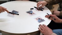 Vitt runt bord med idolhänder som skriver autografer